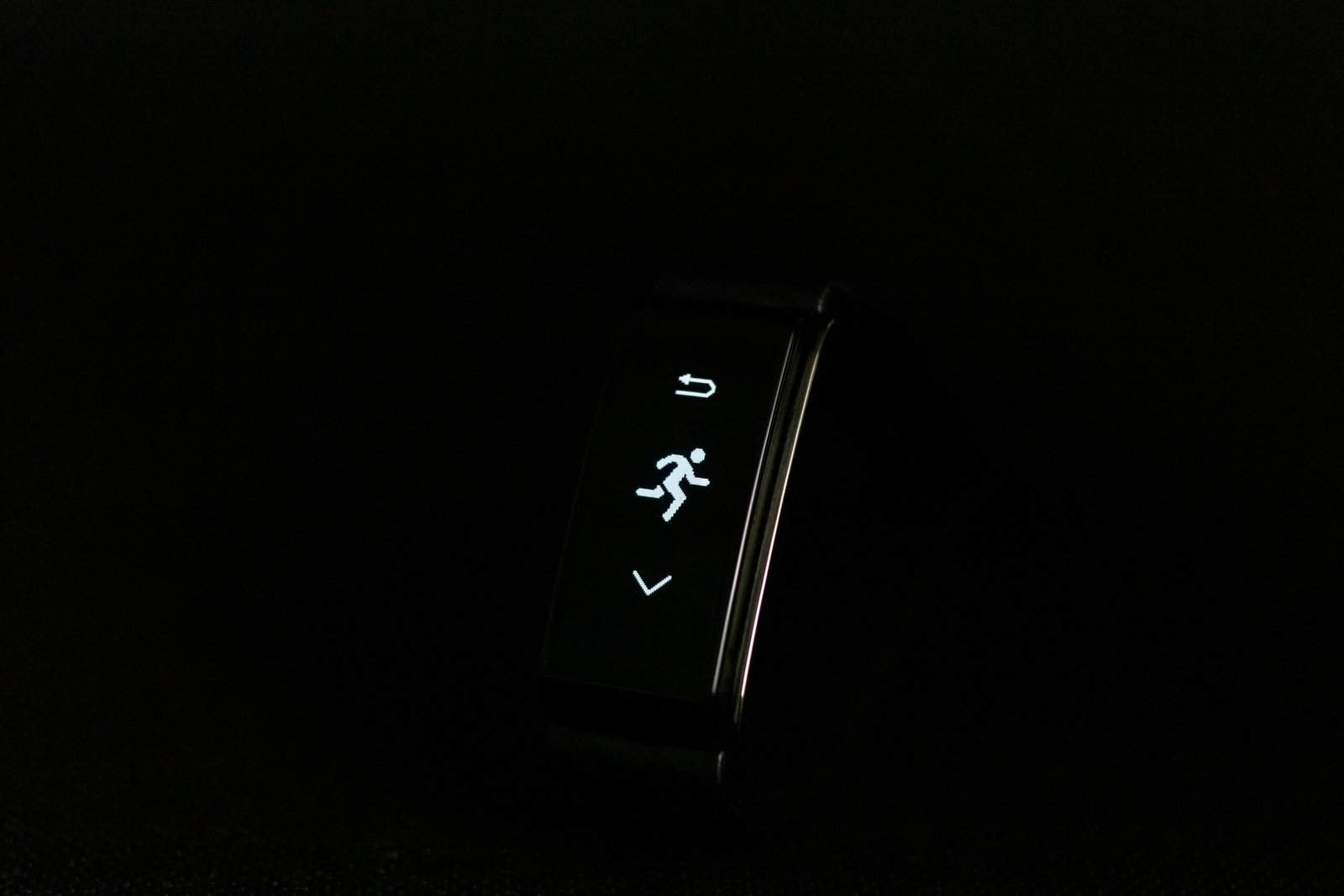 Fitness tracker with running and arrow icons on screen.