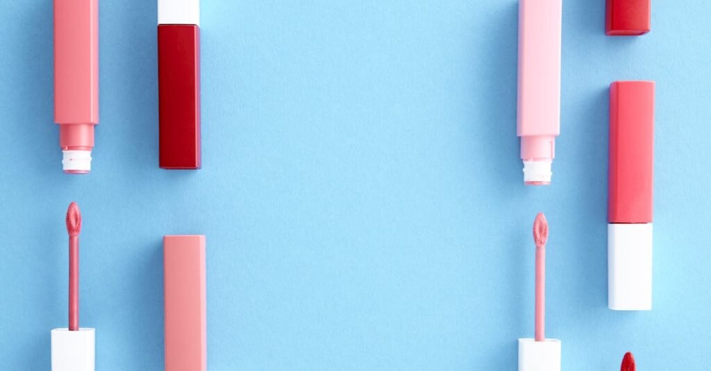 Colorful lip gloss tubes laid out on a bright blue background, showcasing modern cosmetics.