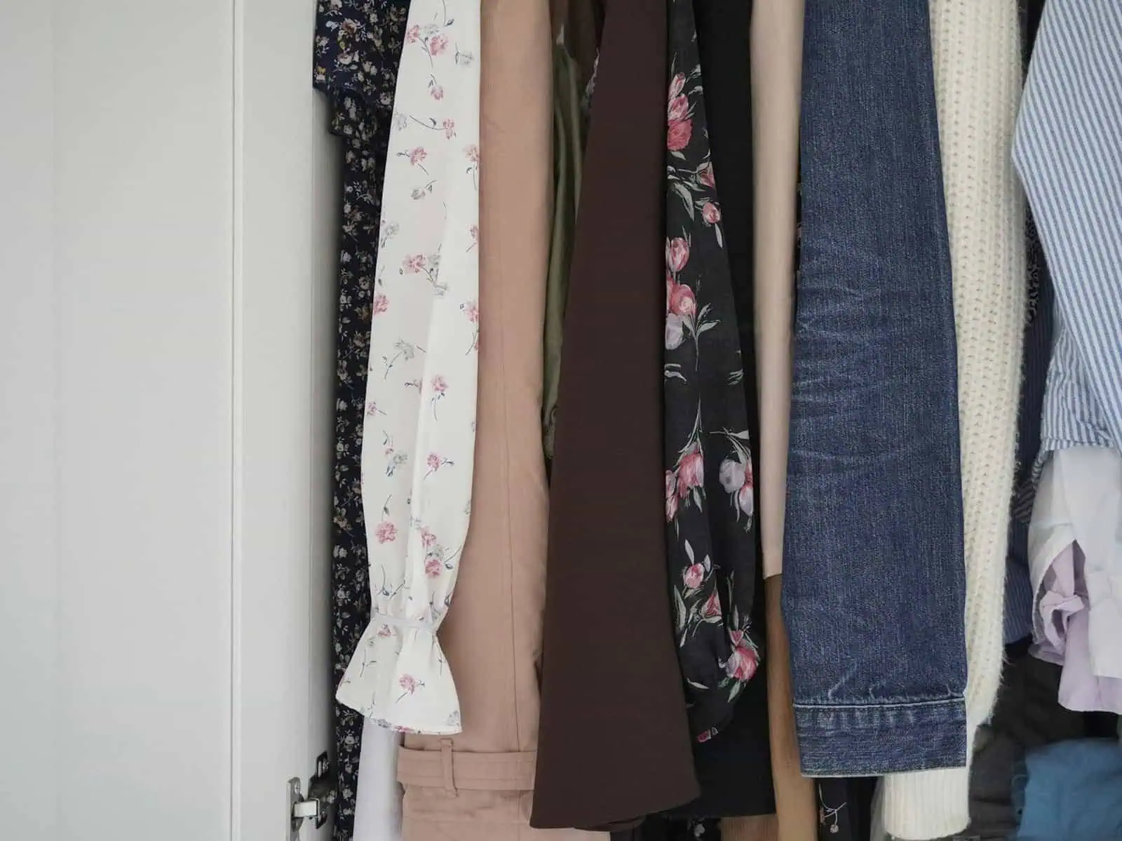 Clothing rack with summer dresses, jeans, and casual wear for women.