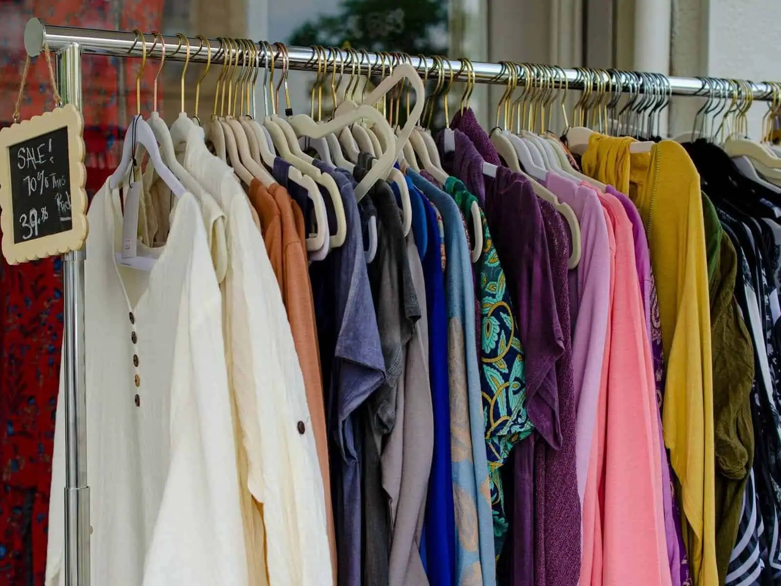 Summer clothing sale with colorful shirts and dresses on display.