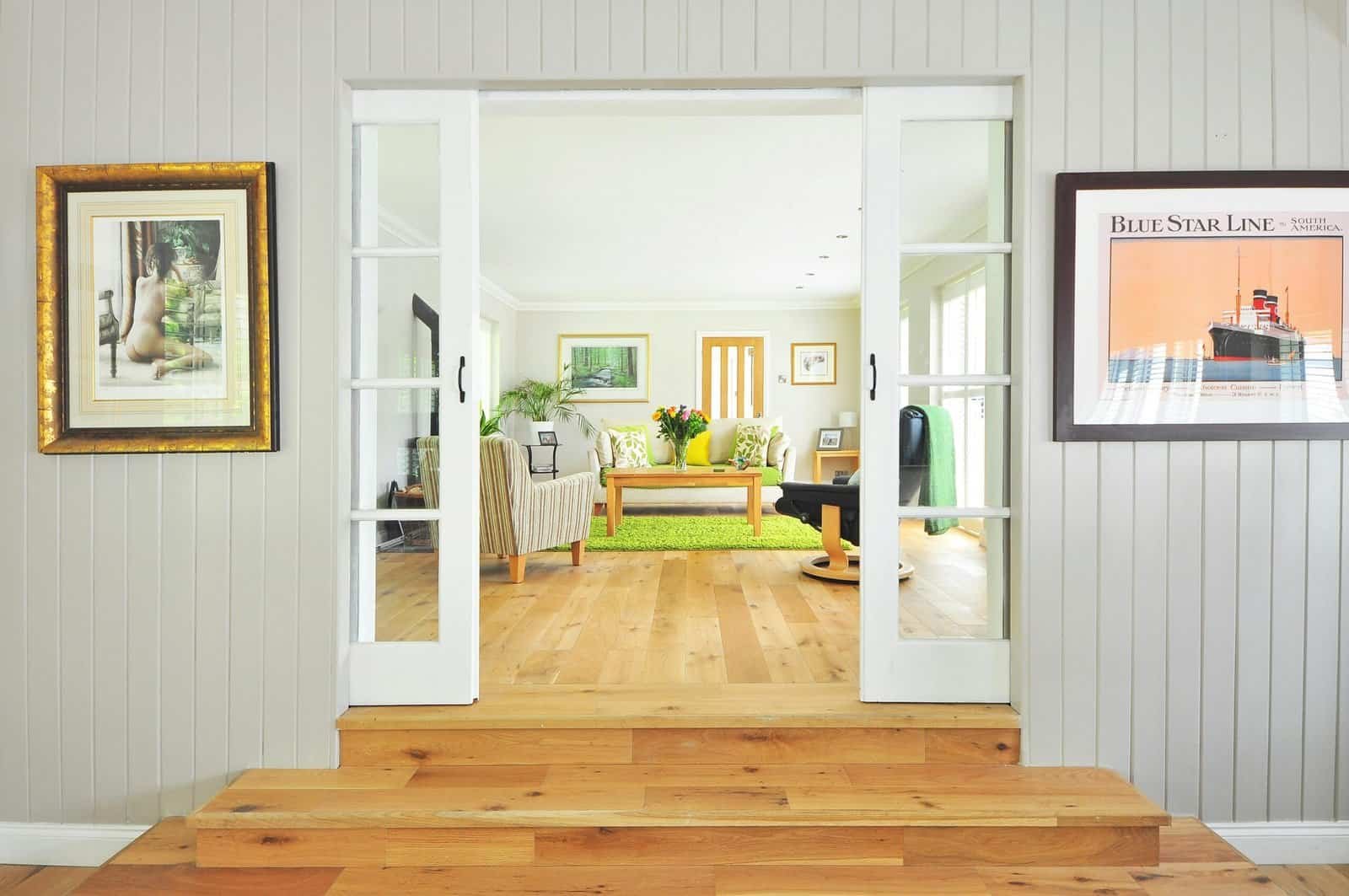 Open living room with bright decor and large doors creating a sense of spaciousness.