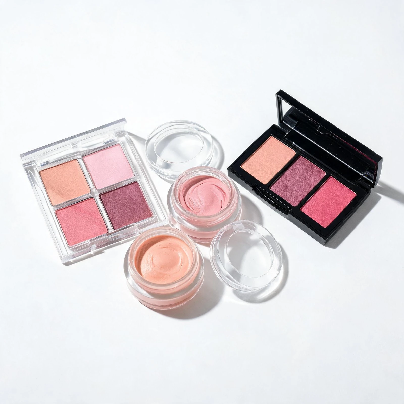 Assorted blush and eyeshadow palettes with pink and peach shades.