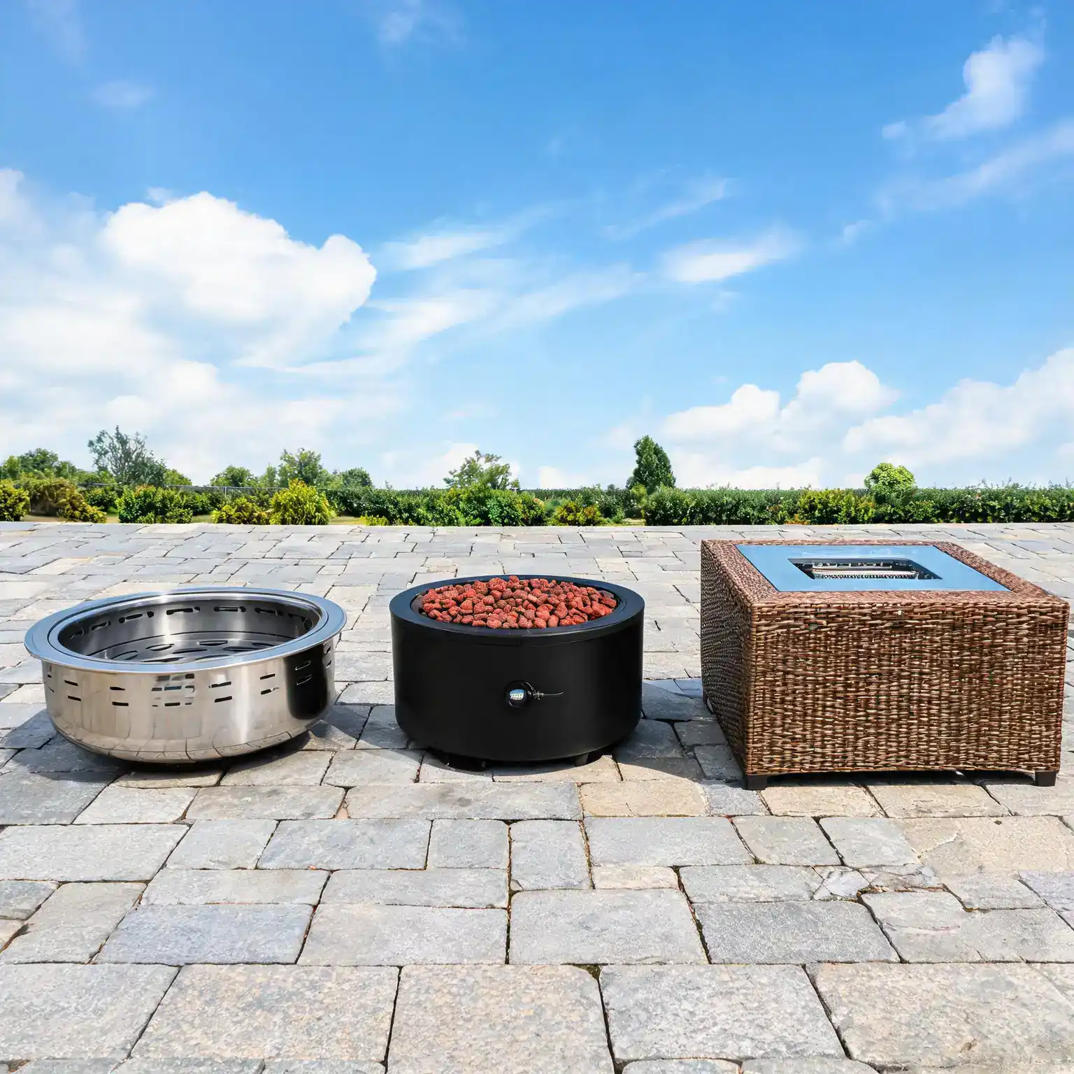 Fire pit types compared: a wood-burning smokeless pit, a propane pit with lava rocks, and a wicker fire pit table on a stone terrace