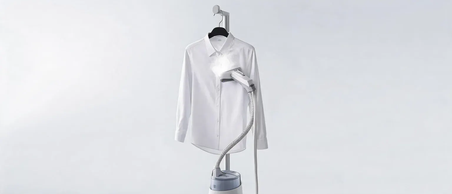 White ironing board with iron on a plain white background.