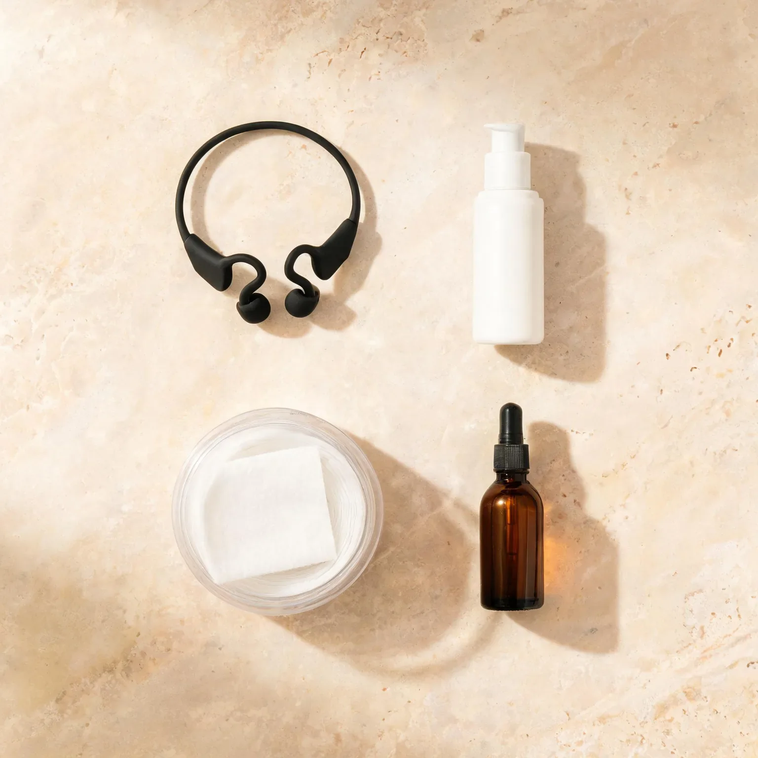 Assorted personal care items including headphones, spray bottle, cotton pads, and dropper bottle.