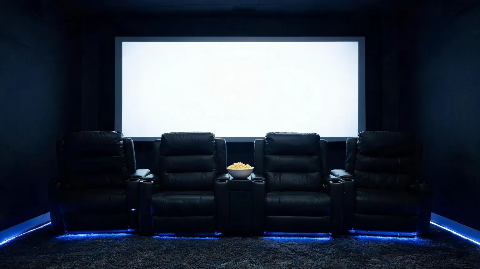 Luxury home theater with five black recliner chairs and a large screen.